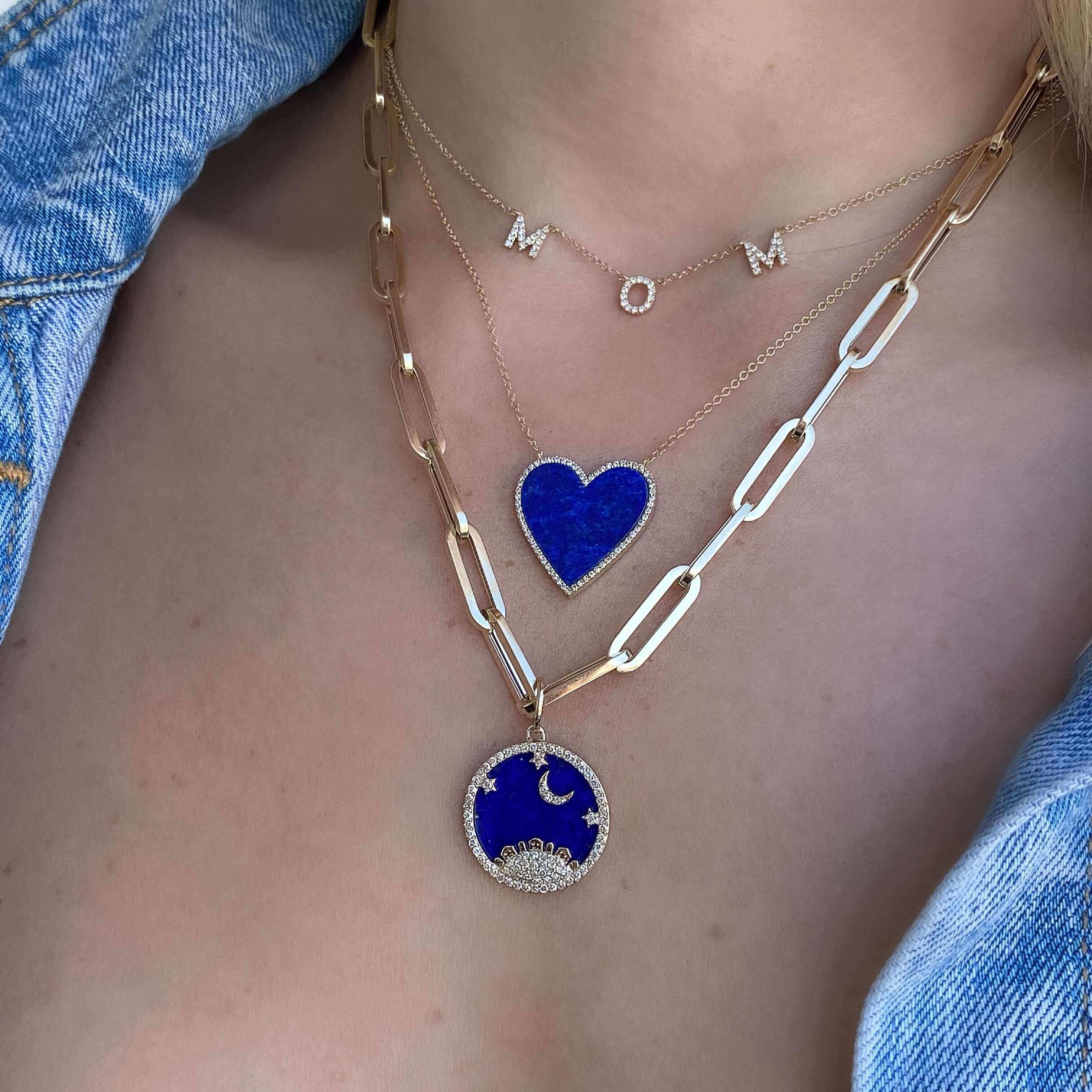 Layered gold necklaces featuring blue heart and moon pendants from our jewelry collection