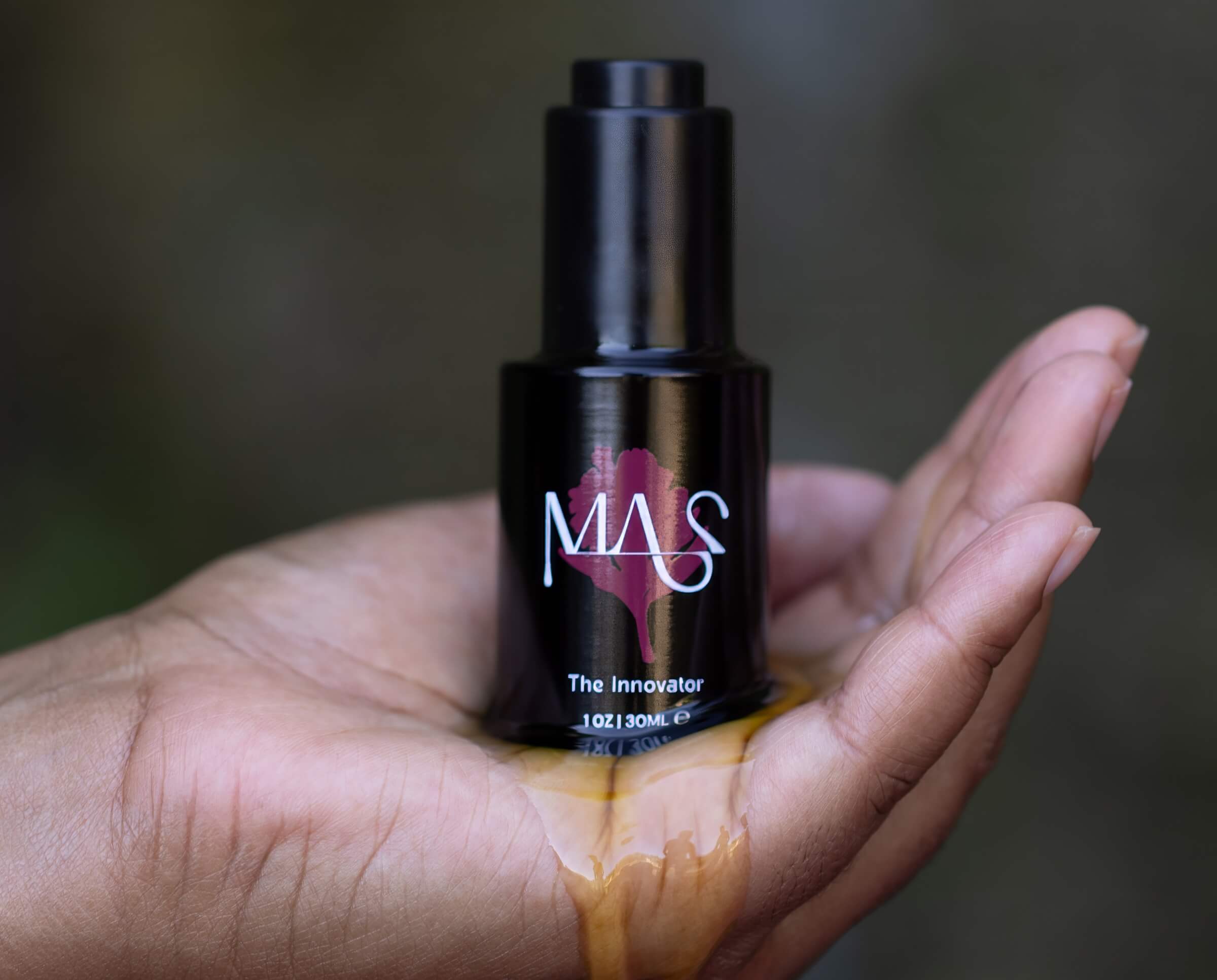 Hand open, holding The Innovator bottle