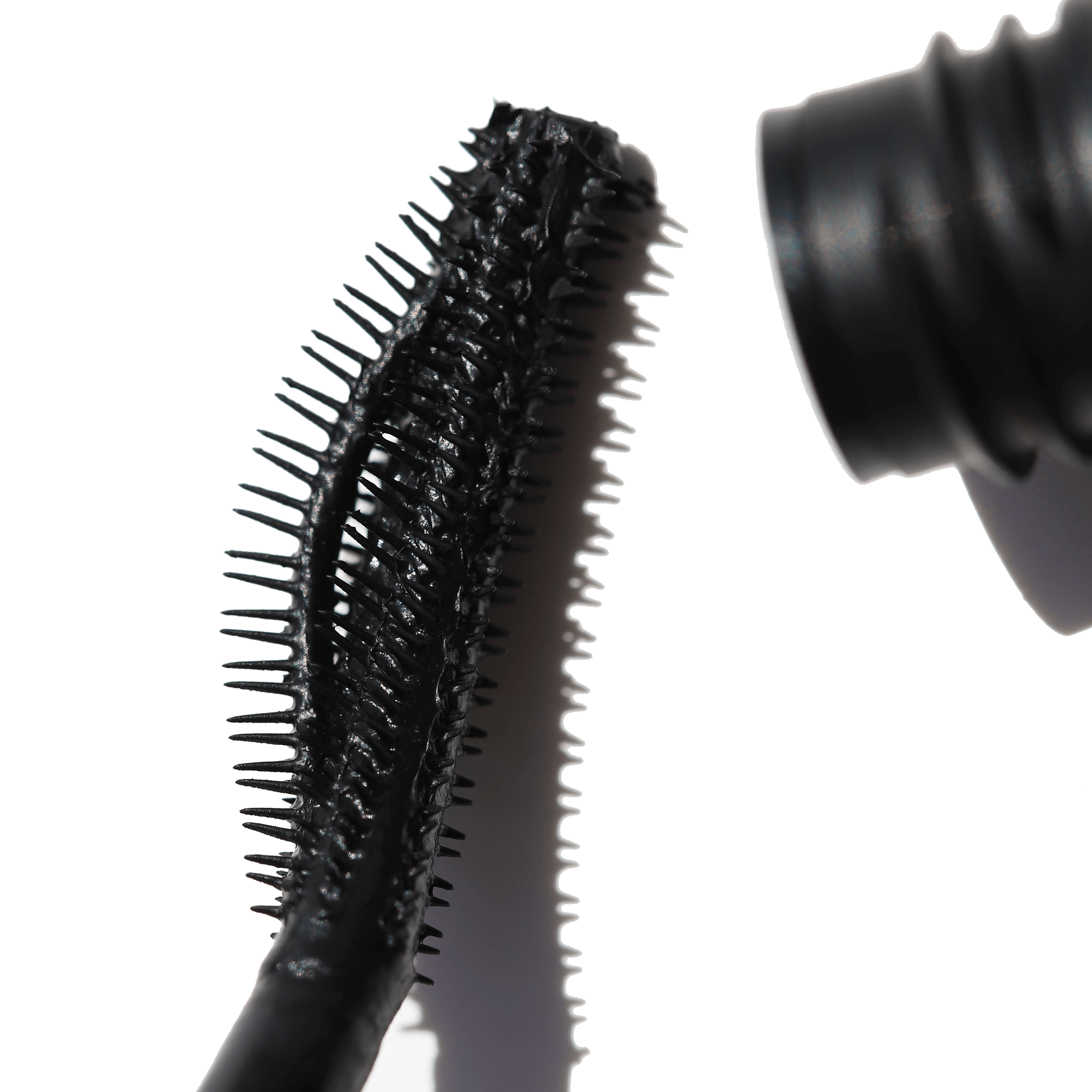 Close-up of the curved brush applicator of Night Show Volumizing Mascara showcasing its innovative suspended bands and precise bristles.