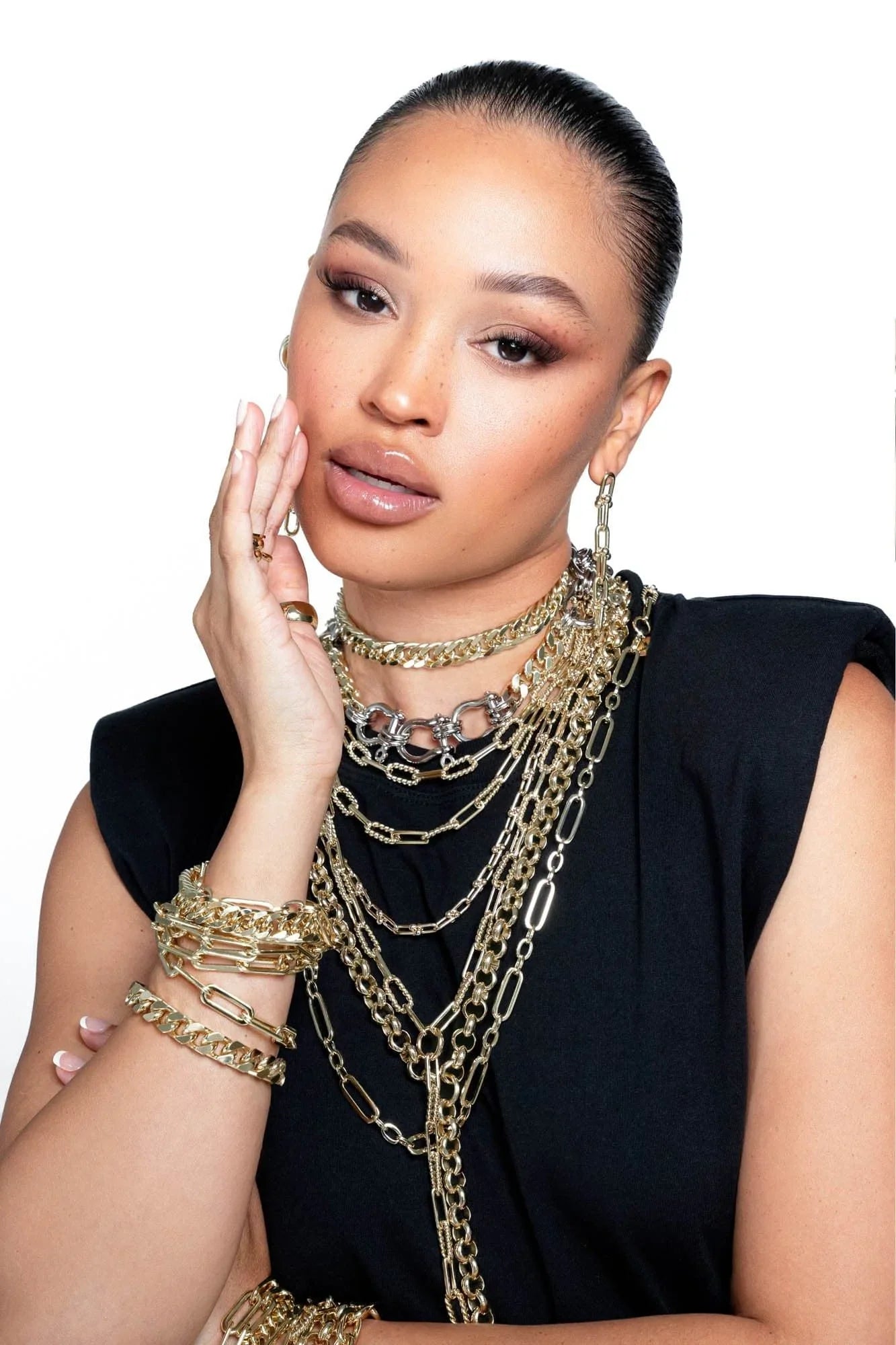 Woman rocking multiple gold chains and bracelets wearing the Dean Necklace style