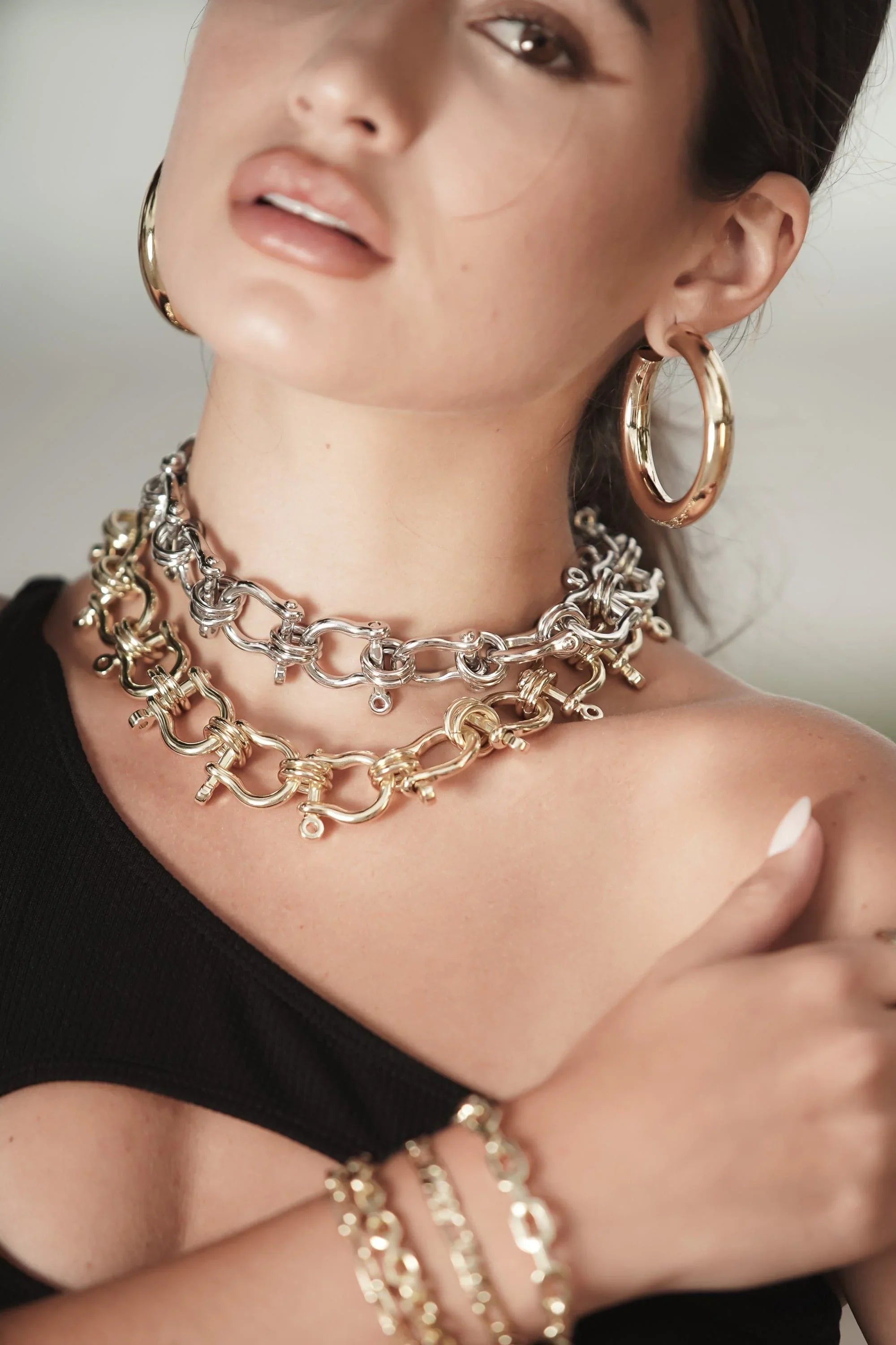 Woman wearing stylish gold and silver jewelry with the Harrison Necklace featured