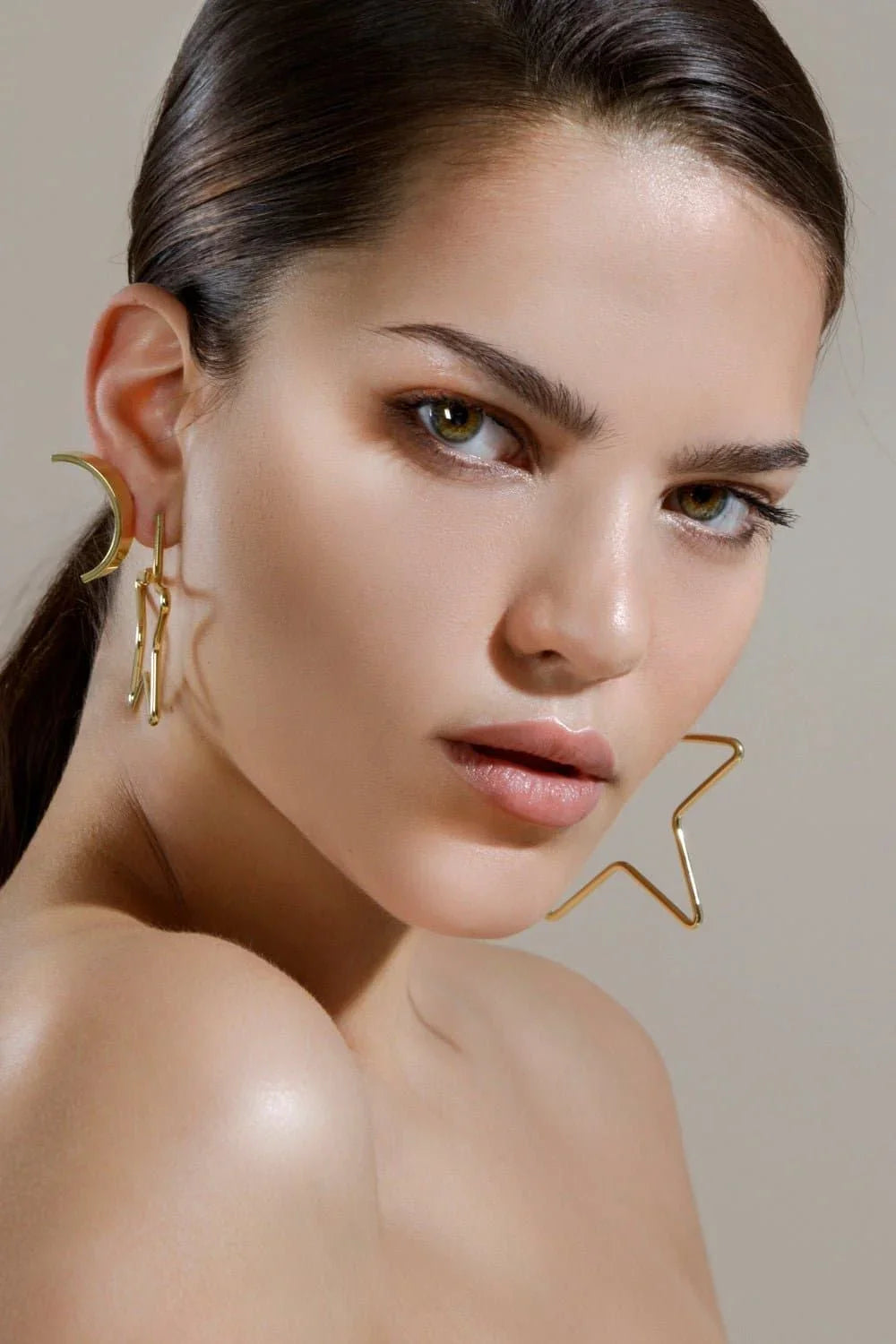 Woman showing off Medium Full Star Earrings with stunning gold celestial design