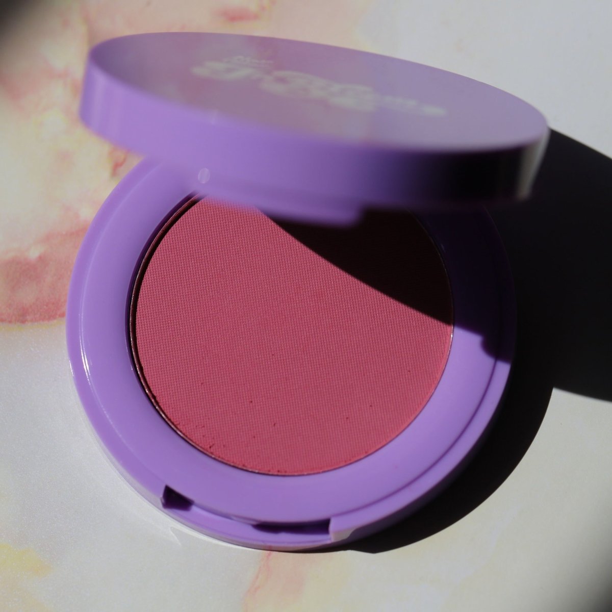 purple compact with pink pan - In Bloom Powder Blush, soft serve - Half Caked
