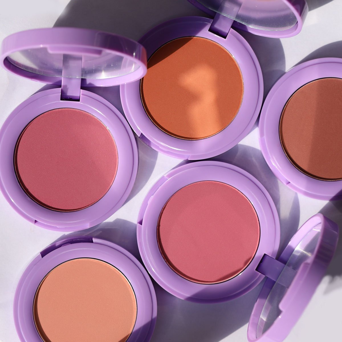 open purple compacts with pink brown and orange pans - In Bloom Powder Blush - Half Caked