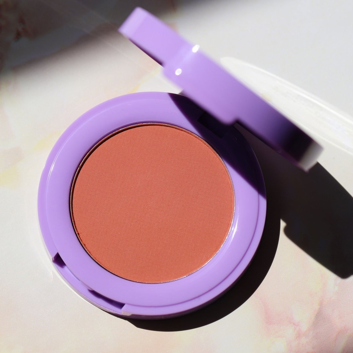 open purple compact with orange pan - In Bloom Powder Blush, liv on sunday - Half Caked