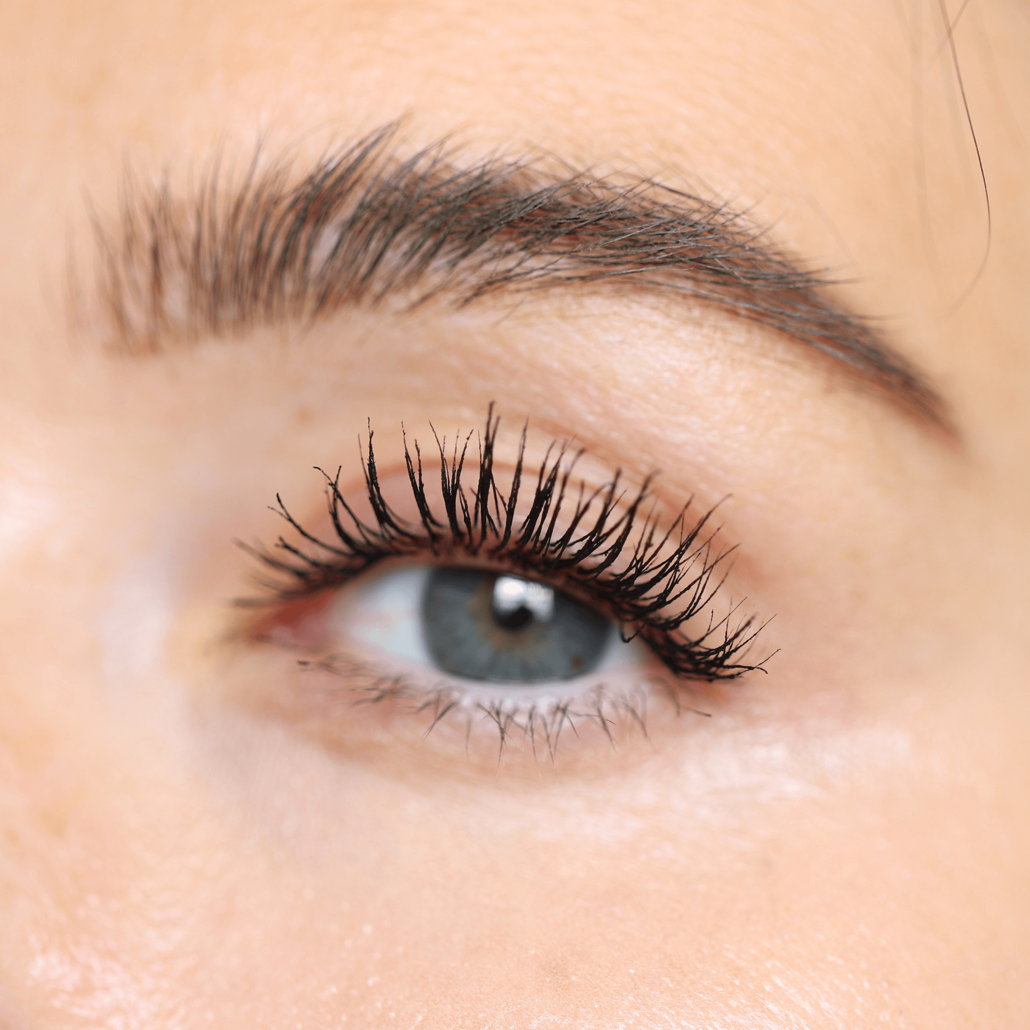 Close-up of an eye with thick, voluminous lashes enhanced by Night Show Volumizing Mascara.