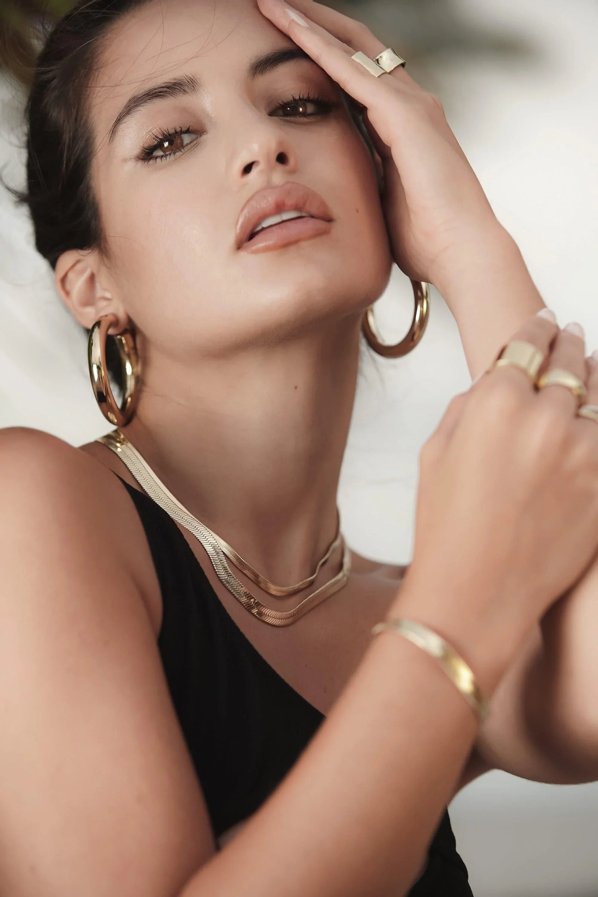 Woman wearing gold jewelry with 1.5 inch Ryan Hoops earrings
