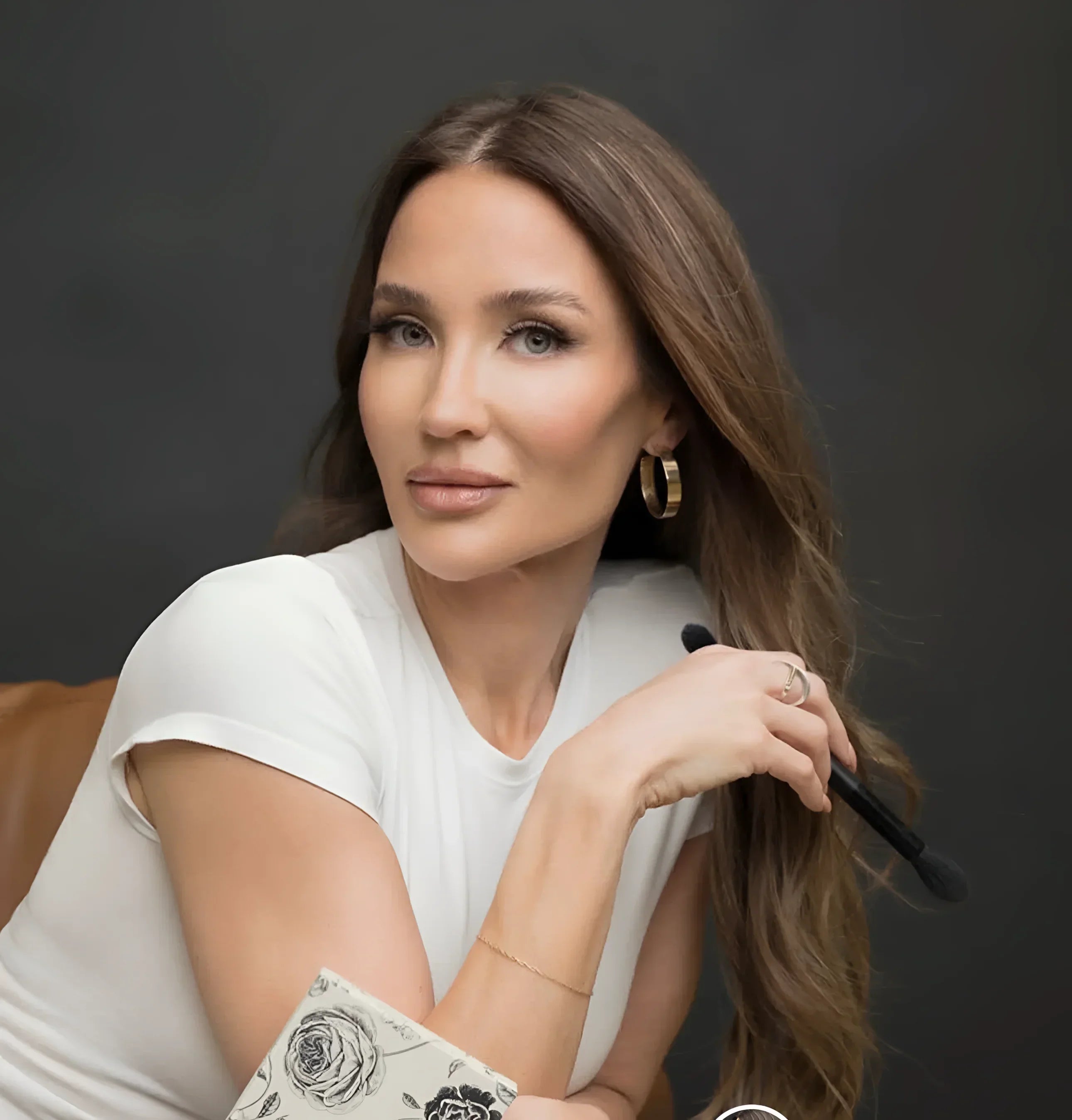 Woman holding makeup brush wearing 1.5 Skylar Hoops in a cool casual shot