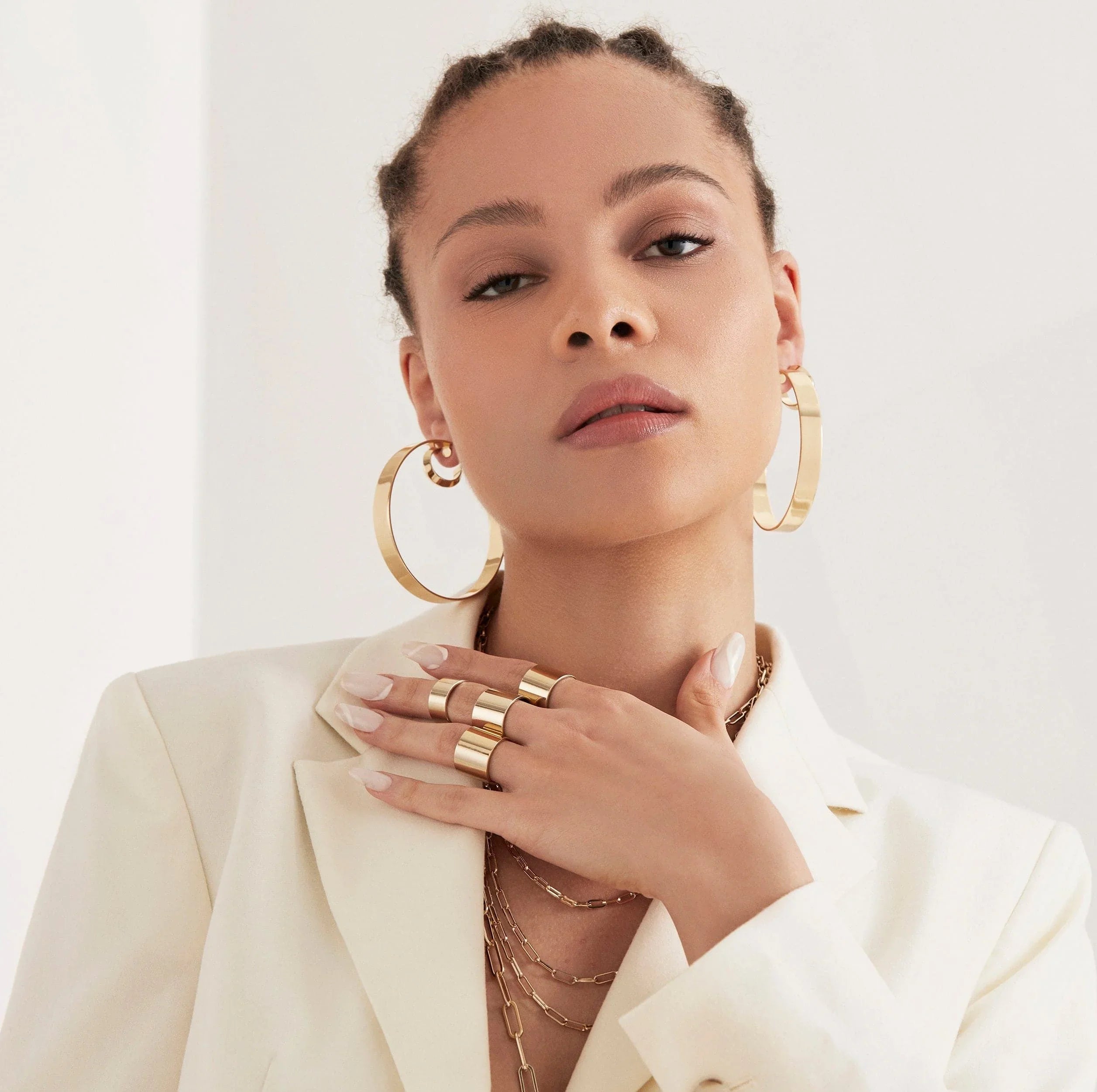 Woman wearing gold jewelry with 2.5 Skylar Hoops dangling stylishly
