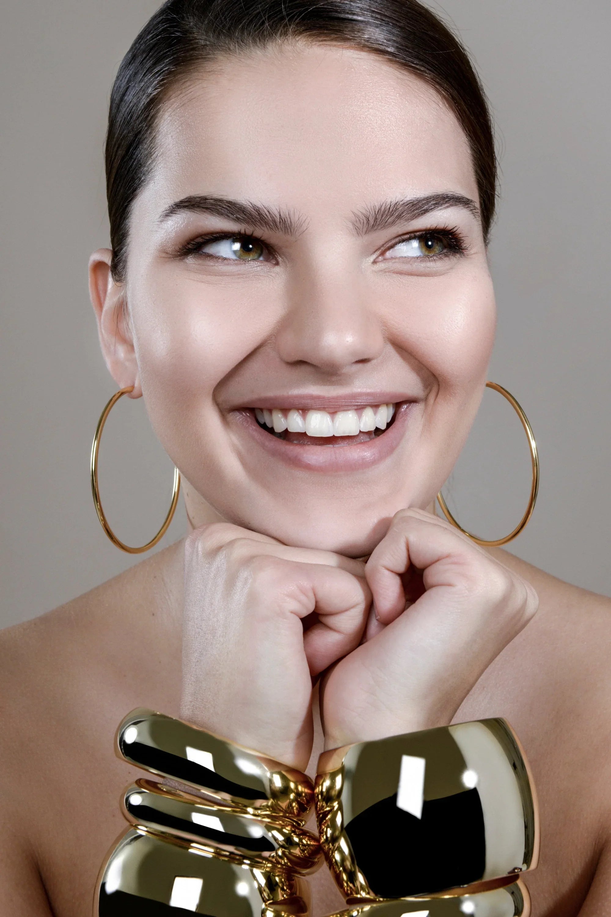 Smiling woman wearing Gold Jewelry with 2.5 Ultimate Hoops earrings
