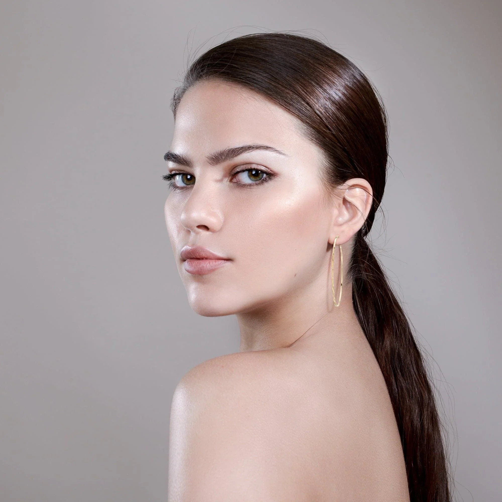 Woman with sleek hair wearing Avery Hoops gold earrings good for any look