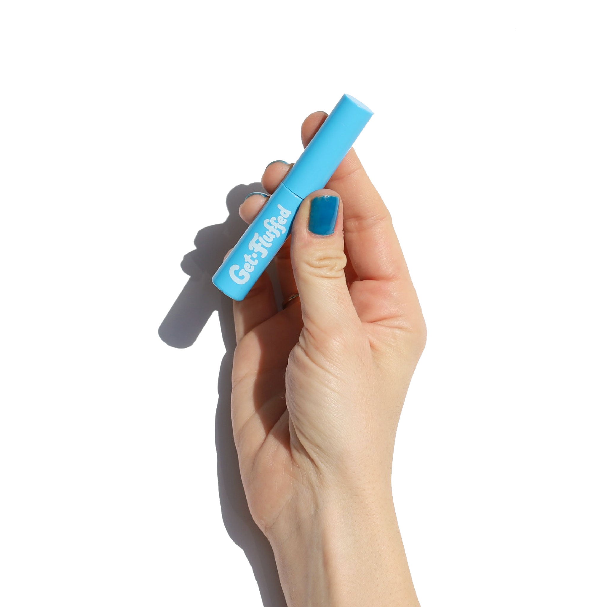 A hand holding a blue tube of "Get-Fluffed Brow Gel" against a white background.