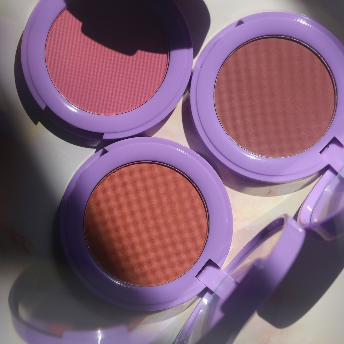open purple compacts with pink orange and brown pans - In Bloom Powder Blush - Half Caked
