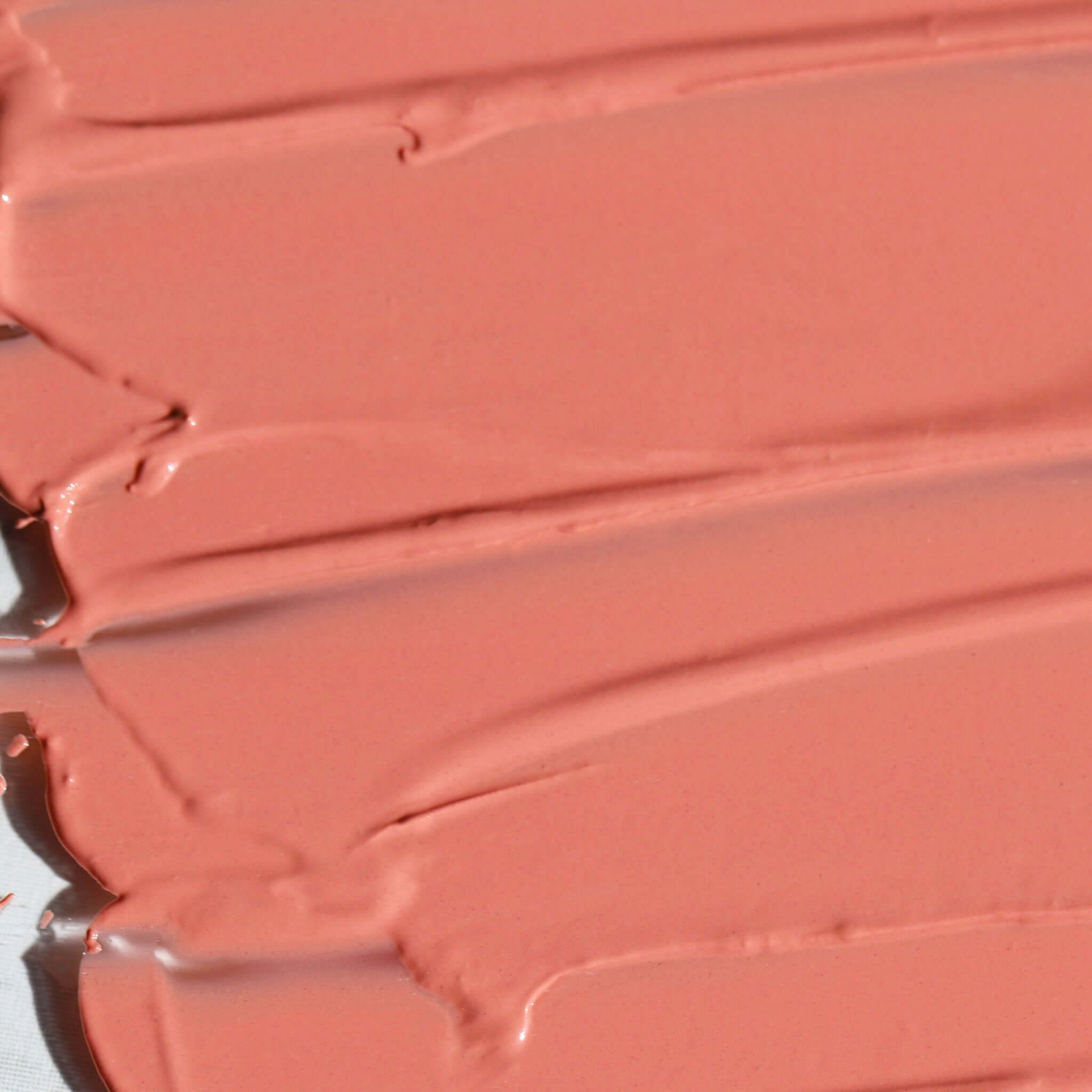 Close-up of Candy Paint Cheek + Lip Tint creamy texture in a soft peachy shade, highlighting the dewy and blendable formula.