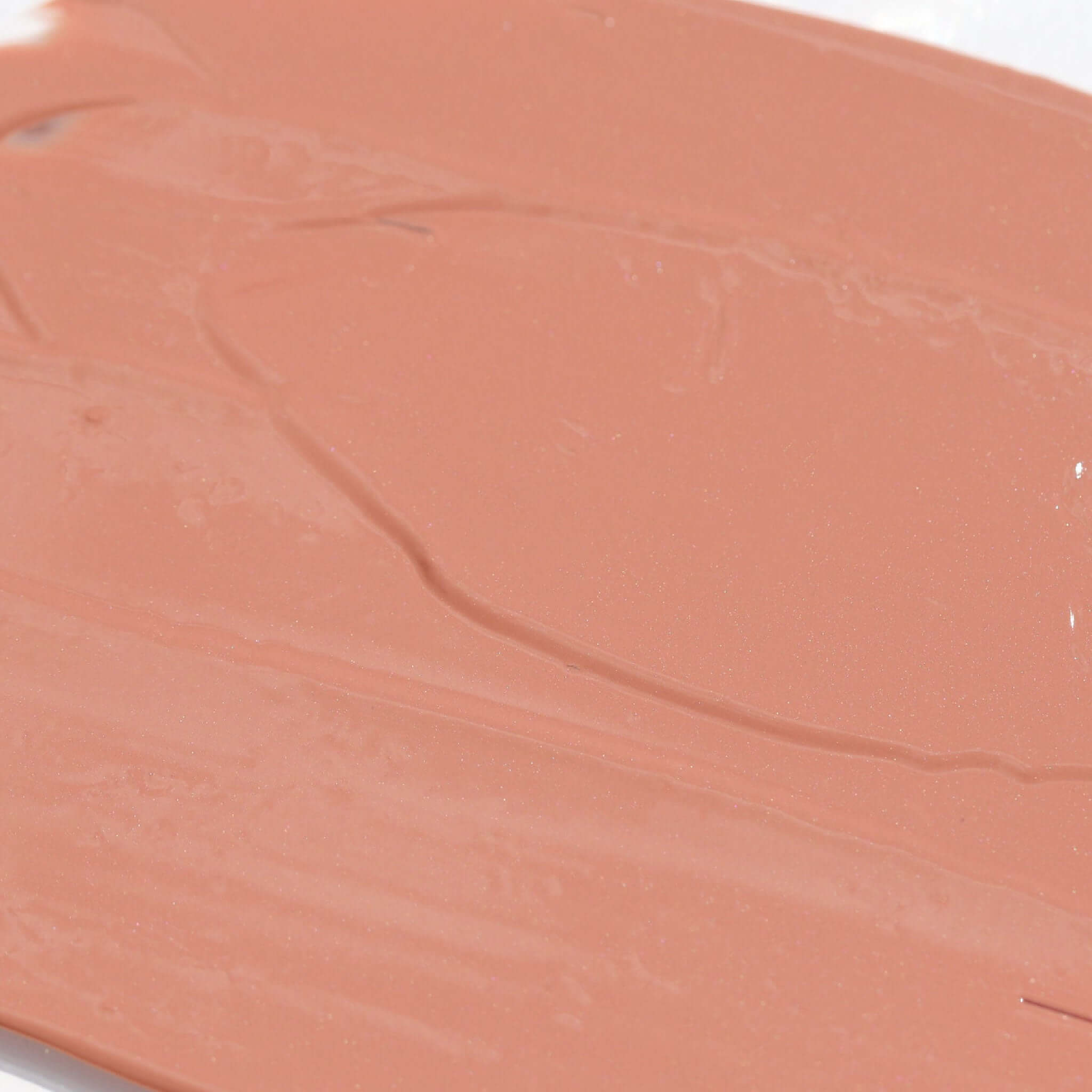 Close-up of the creamy texture of Candy Paint Cheek + Lip Tint in a peachy shade, showcasing its blendable formula and dewy finish.